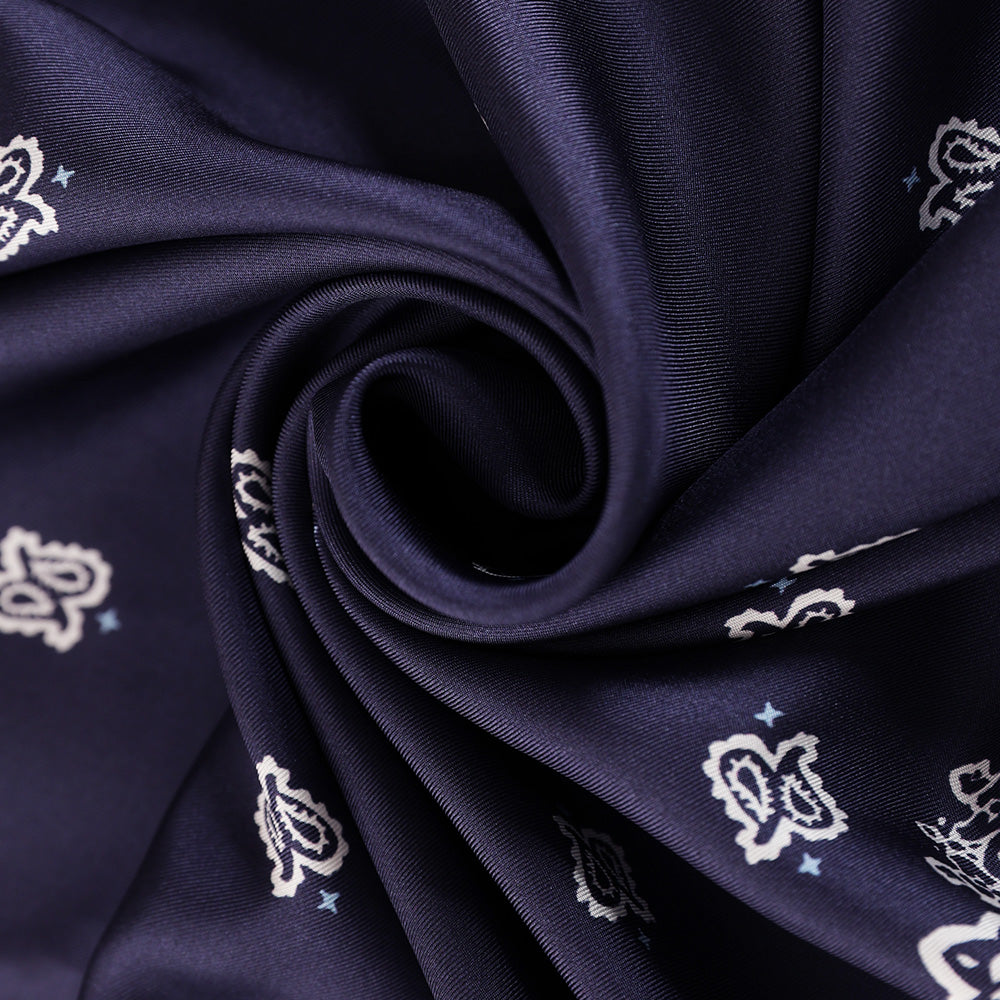 Close-up of the navy and white paisley silk scarf print