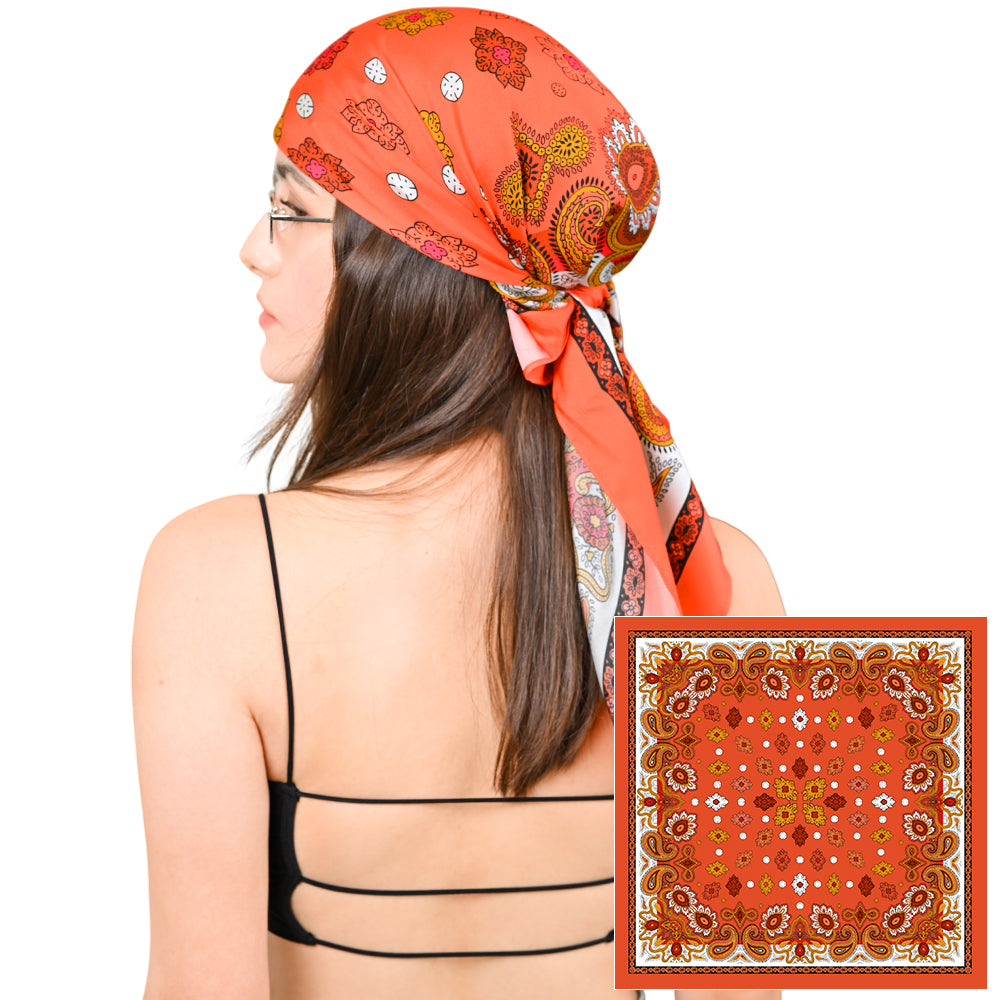 Model styling a vivid orange silk scarf with gold paisley print as a headscarf