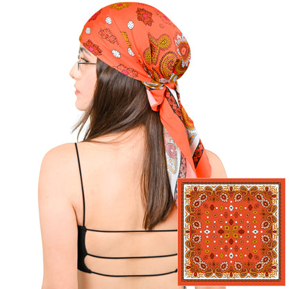 Model styling a vivid orange silk scarf with gold paisley print as a headscarf