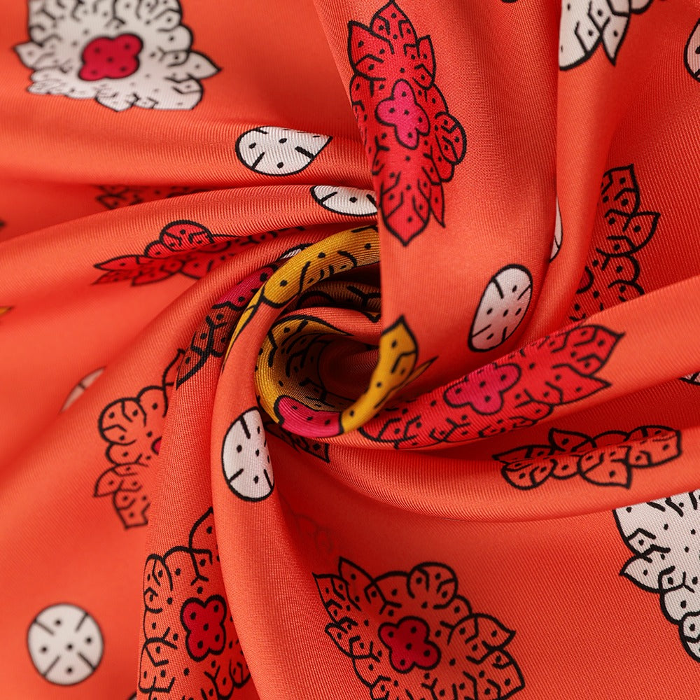 Close-up of the orange silk scarf's paisley and geometric floral print