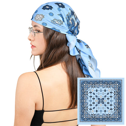Model styling a light blue silk scarf with navy paisley print as a headscarf