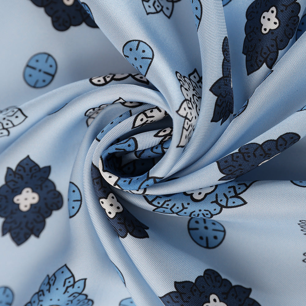 Close-up of the light blue silk scarf's navy paisley print