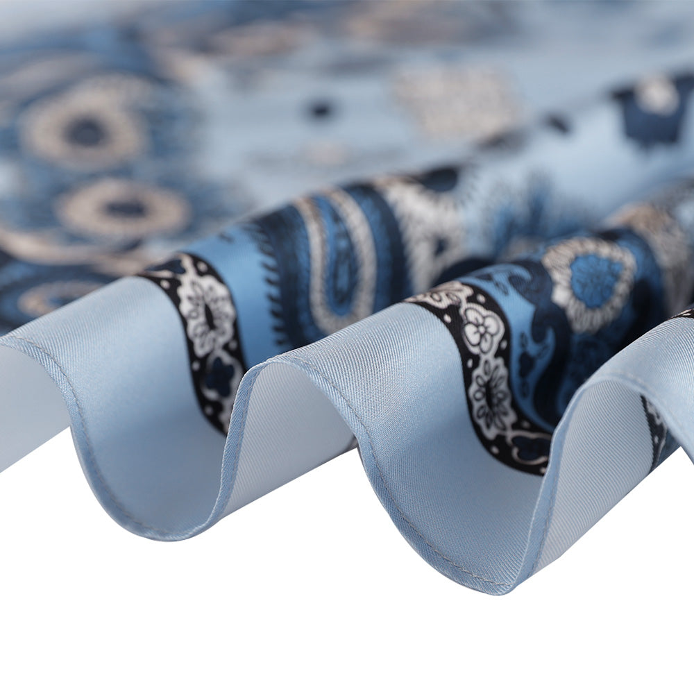 Close-up of the light blue paisley silk scarf edge