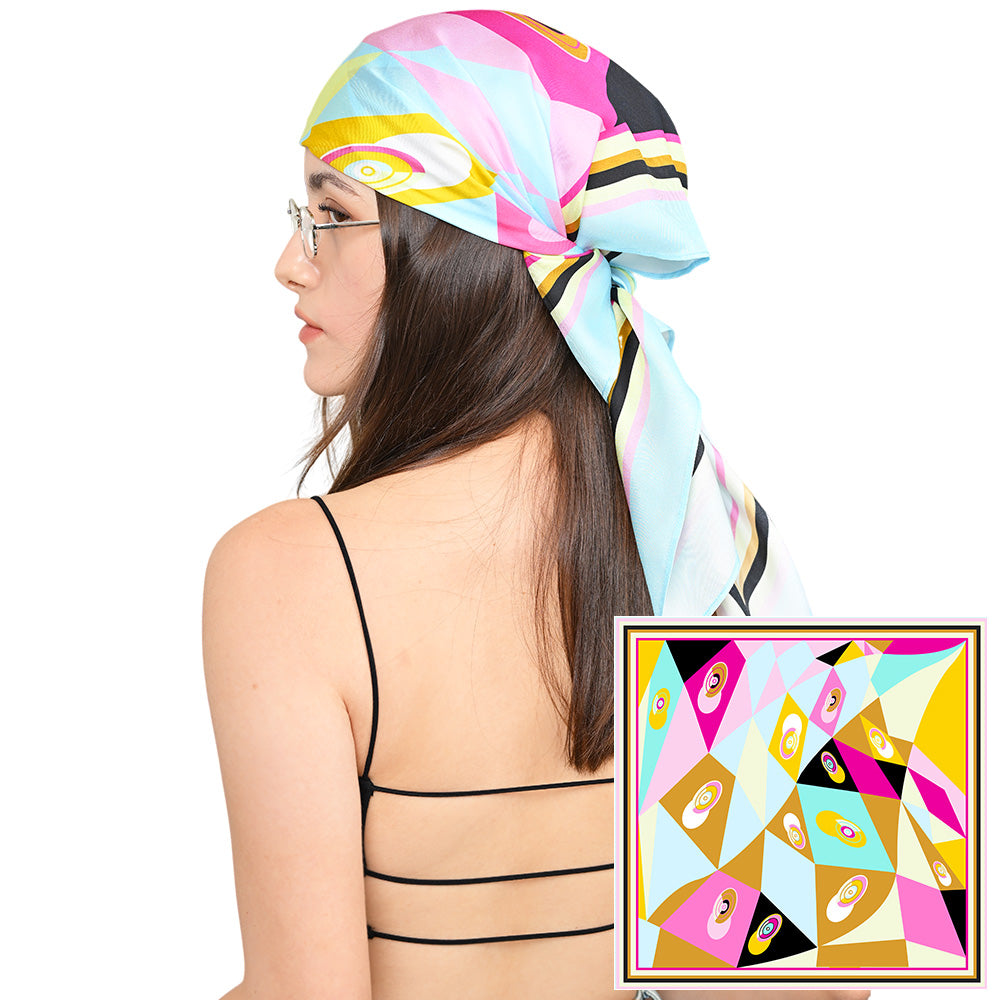 Model styling a colorful geometric silk scarf as a headscarf